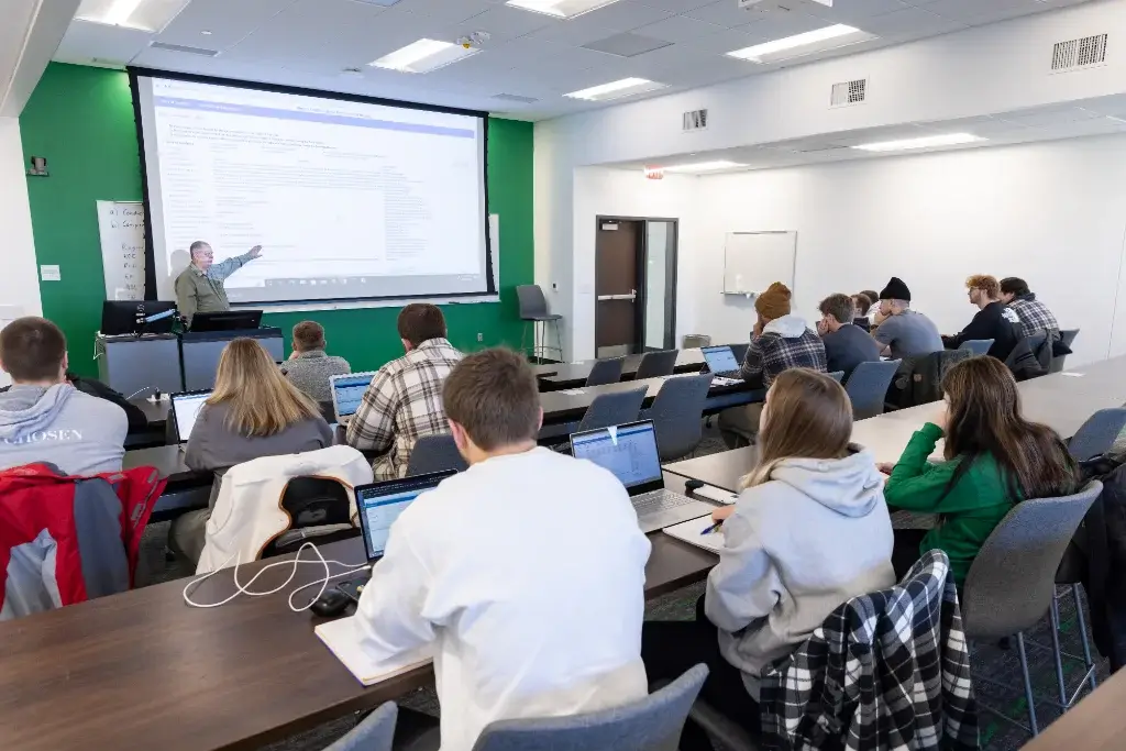 A group of students listening to an operations management lecture in a classroom.