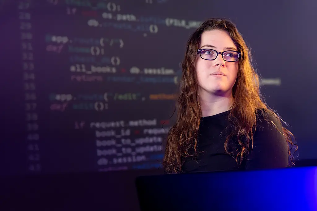 A cybersecurity engineering student coding and analyzing complex software for a university programming project.