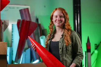an aerospace engineering student holding a prototype