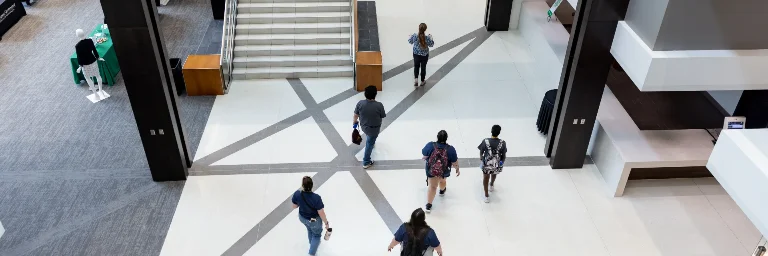 Group of students walking through UND's campus on their way to business management lecture.