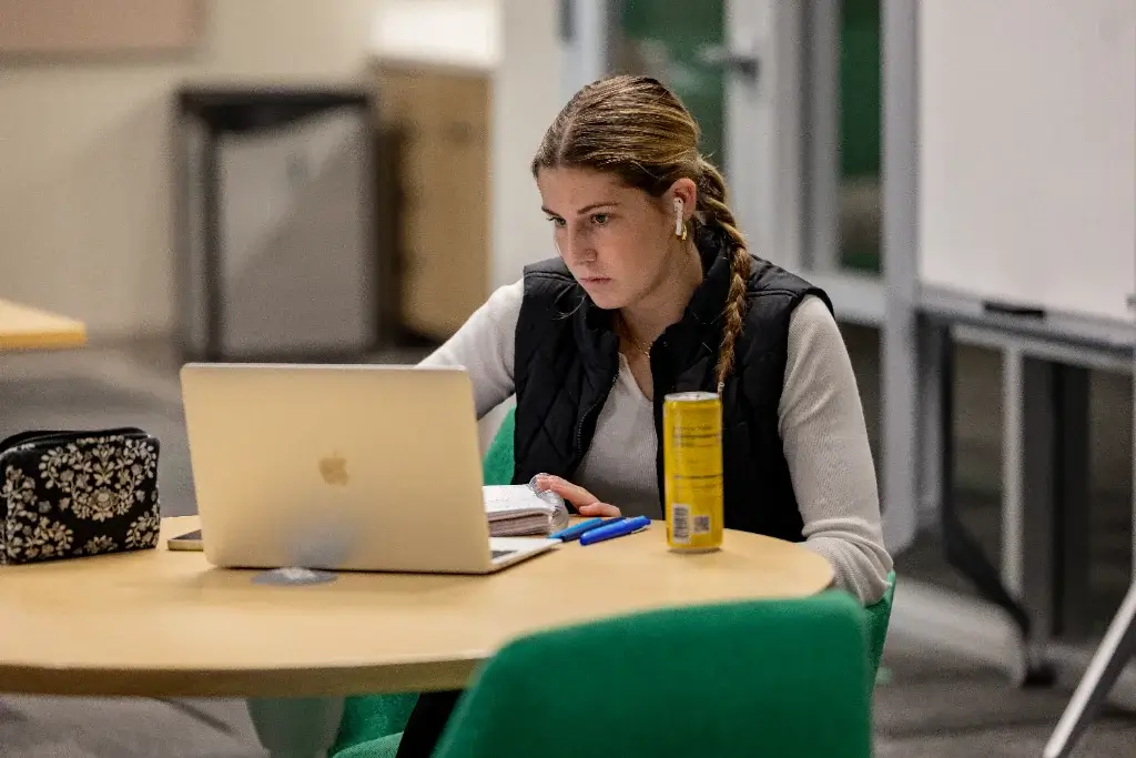 a female cybersecurity student studying in the campus cafeteria
