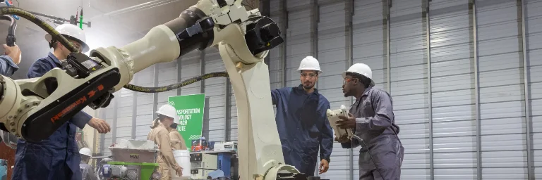 three mechanical engineers examining a machine
