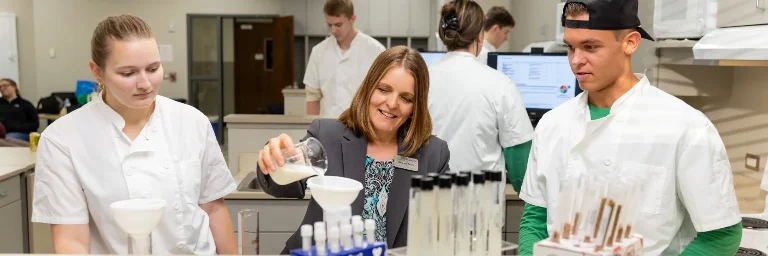 Students and a female professor in a lab, learning about food science nutrition.