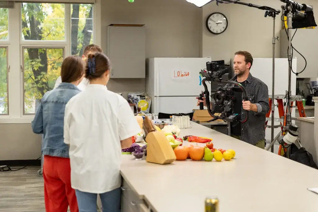 A diverse group of people gathered around a counter, discussing nutrition awareness.