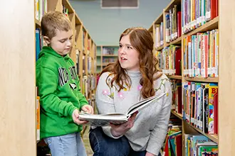 A UND early childhood student reading to young children.