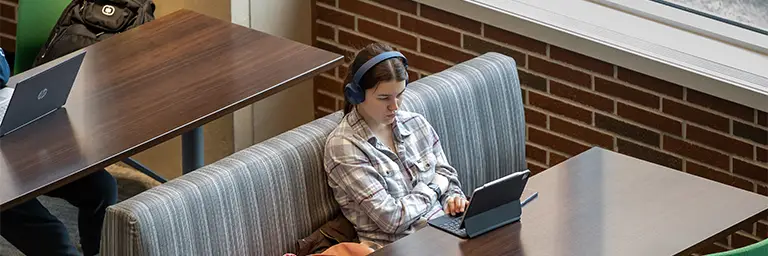 An MPA student focused on her laptop, researching career opportunities in public administration