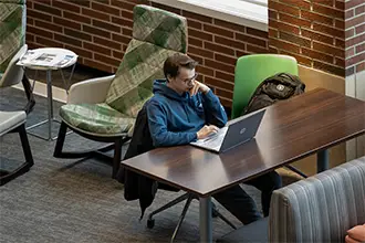 An MPA male student browsing career options on his laptop