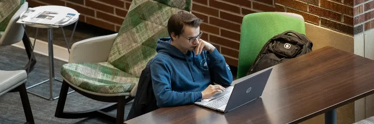 a cybersecurity student sitting alone in the library