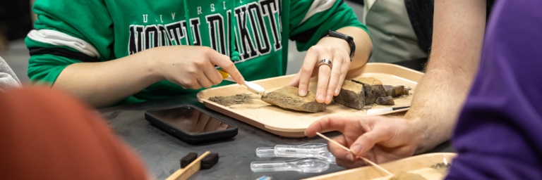 A UND student is studying a fossil excavation.