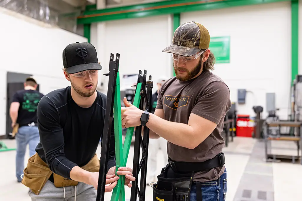Engineering students collaborating on a hands-on structural project in a workshop, showcasing the teamwork required in an engineering career.