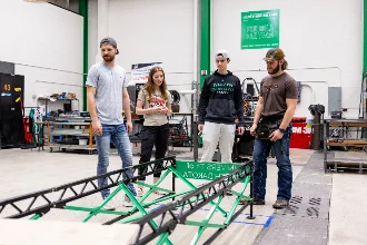 Group of students collaborating on a civil engineering project in a workshop.