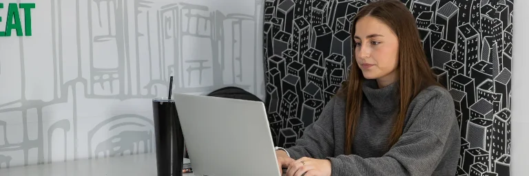 A business management student sitting in front of a laptop, focused on her work.