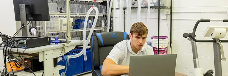 A UND biology student analyzing data in a lab