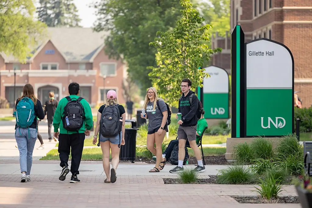 Students walking past the Gillette Hall on UND's engineering campus during the summer semester.