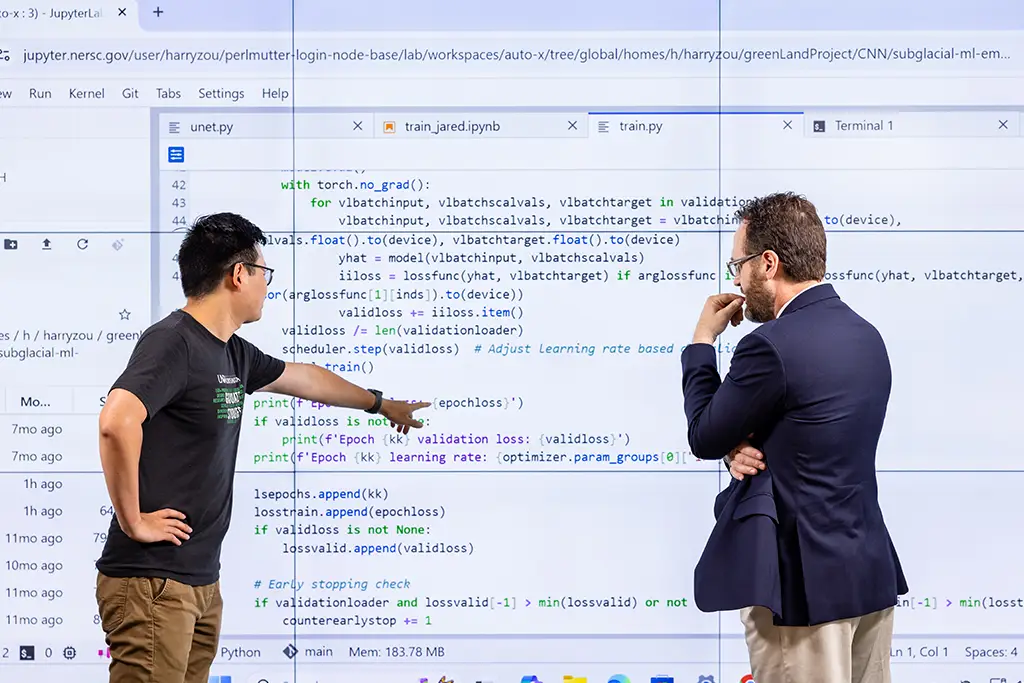 Two researchers collaborating on and debugging Python code to demonstrate how machine learning and AI work together to train a neural network model.