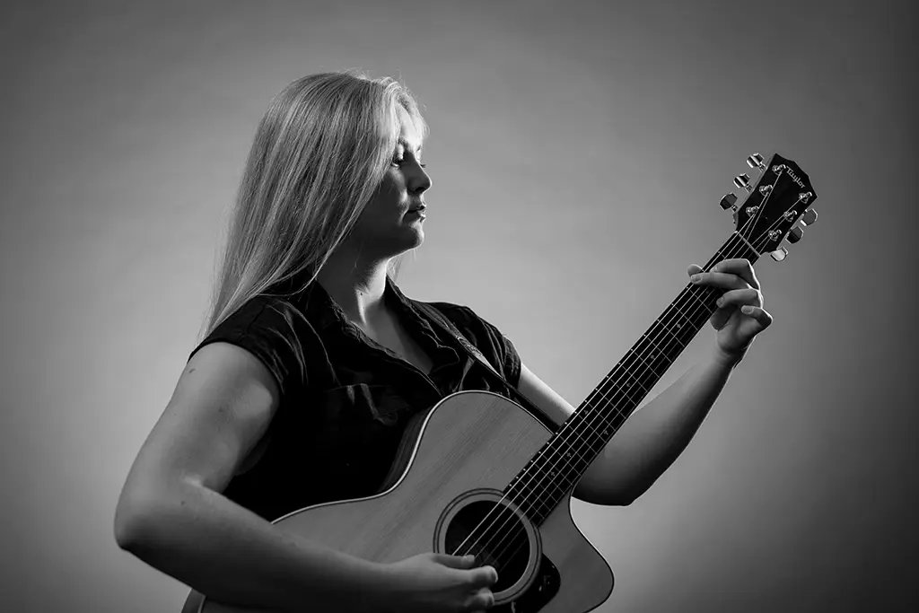 aubrey playing guitar in black and white image