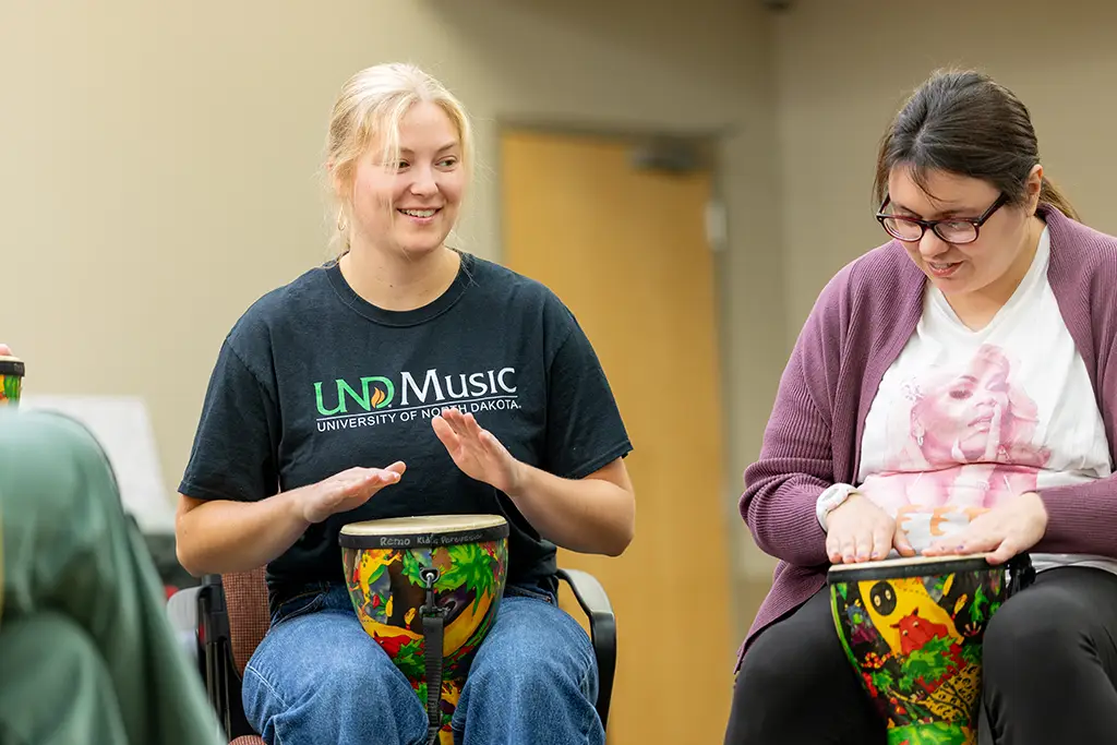 aubrey playing a drum in a music therapy class
