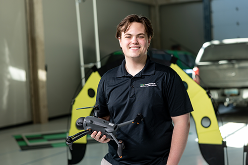 Greyson Orne holding a UAS drone and smiling