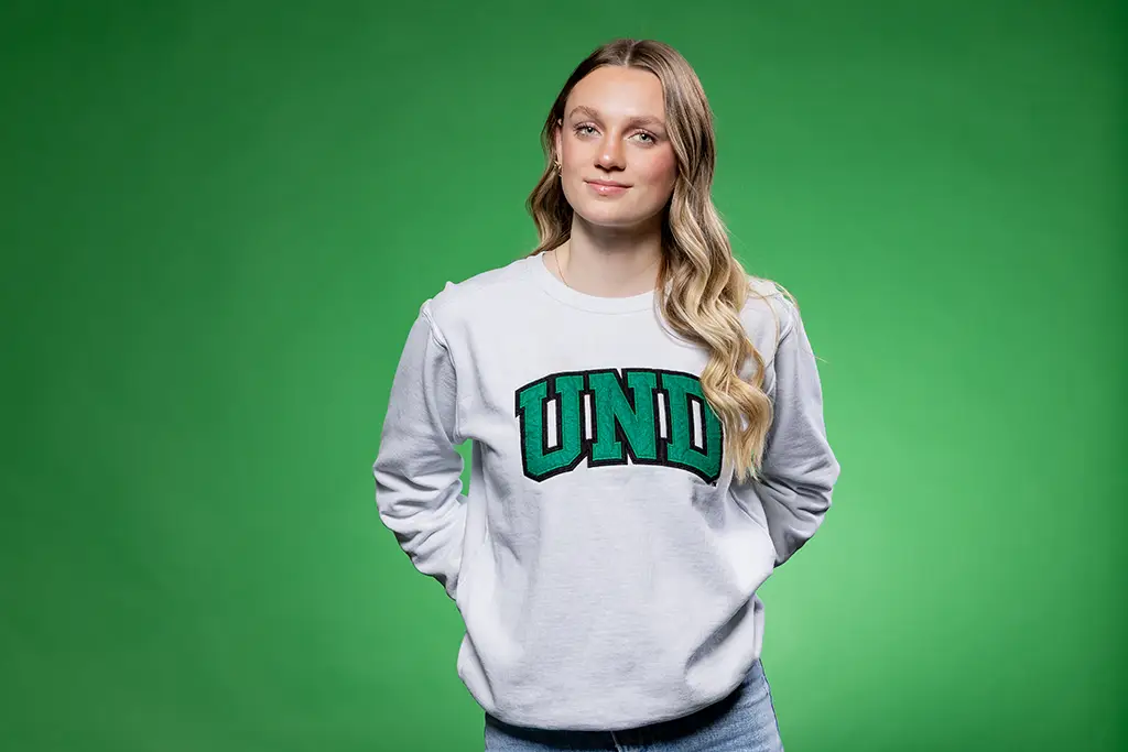 jenna koppelsloen in front of green screen with UND sweatshirt