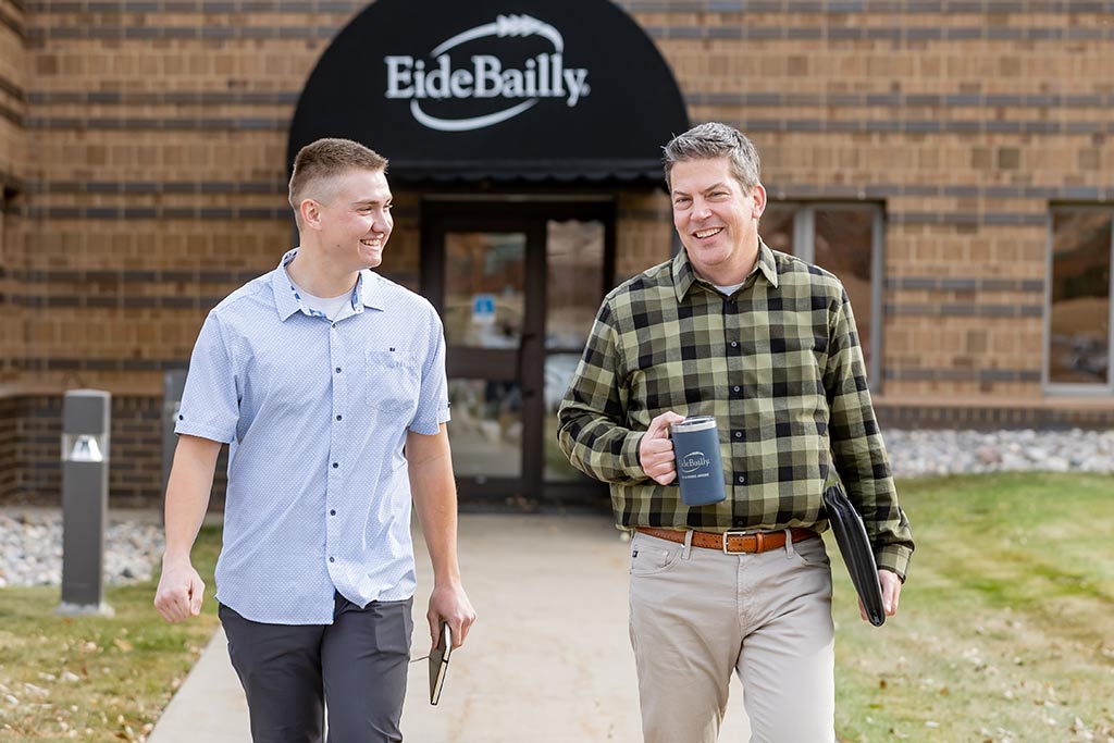 Kaden walking with male coworker at Eide Bailly.