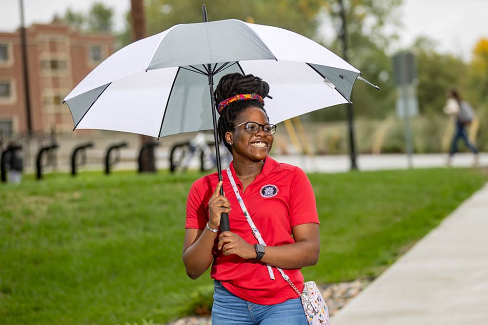 Malika with umbrella on campus