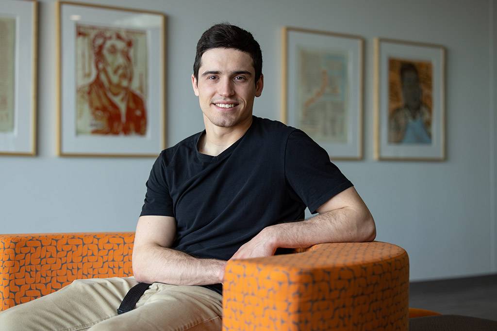 Merrick smiling sitting in orange chair