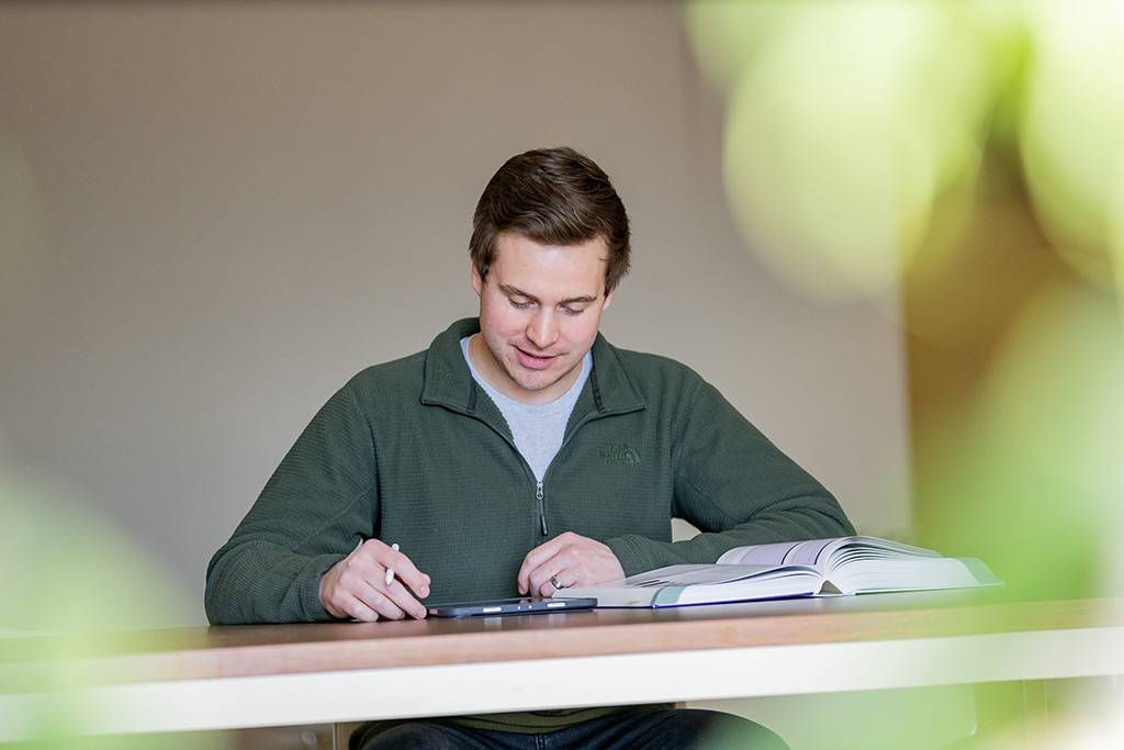 Nick Houge studies with open book at table