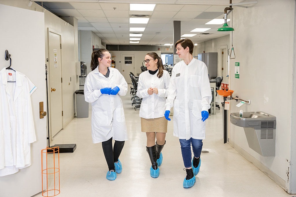 three women walking in forensic science lab