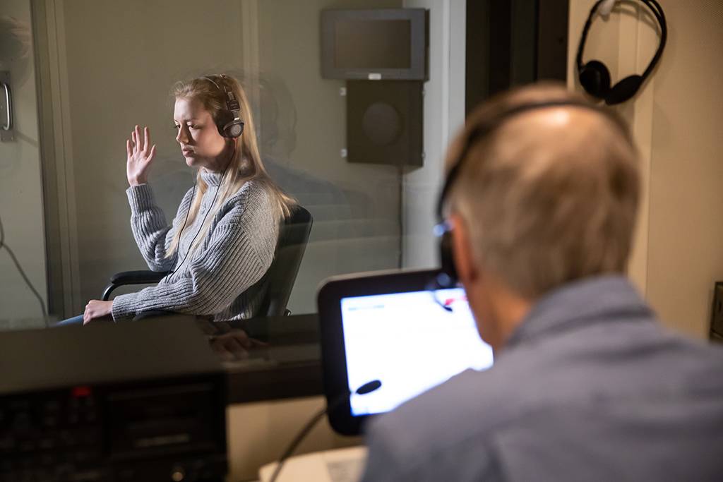 Olivia raising hand in hearing test