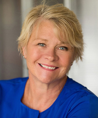 Headshot of Mary with smiling with a blue blouse