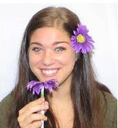 Person holding flowers near their face.