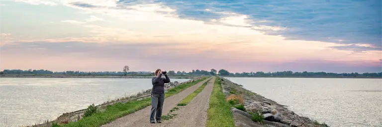 UND Female Biology Student Outside Looking Through Binoculars