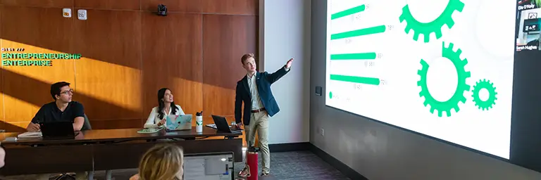 business students in class looking at big screen