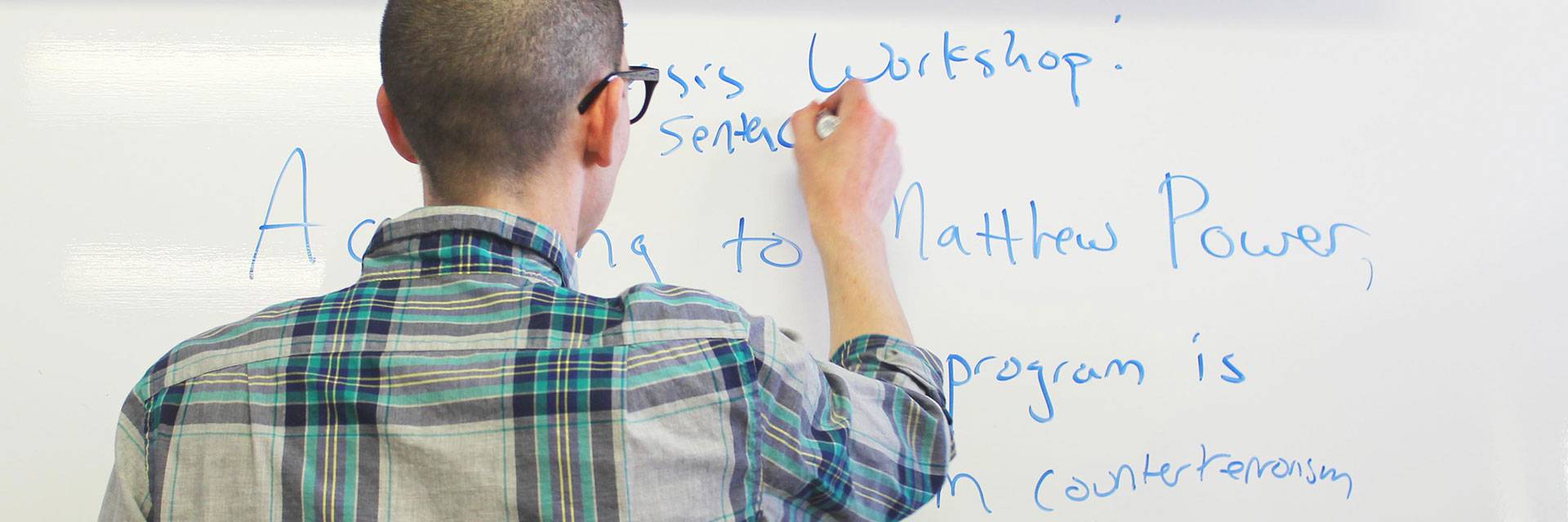 english master's student writing at whiteboard