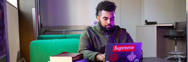 student working on laptop in study area