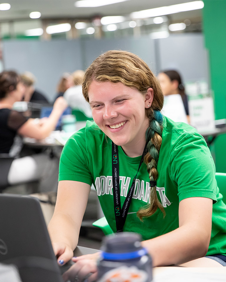student smiling at her computer 