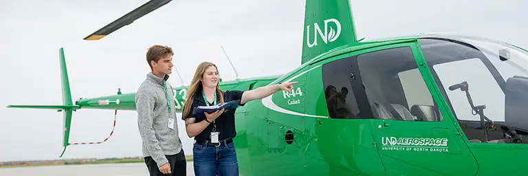 students standing outside UND helicopter