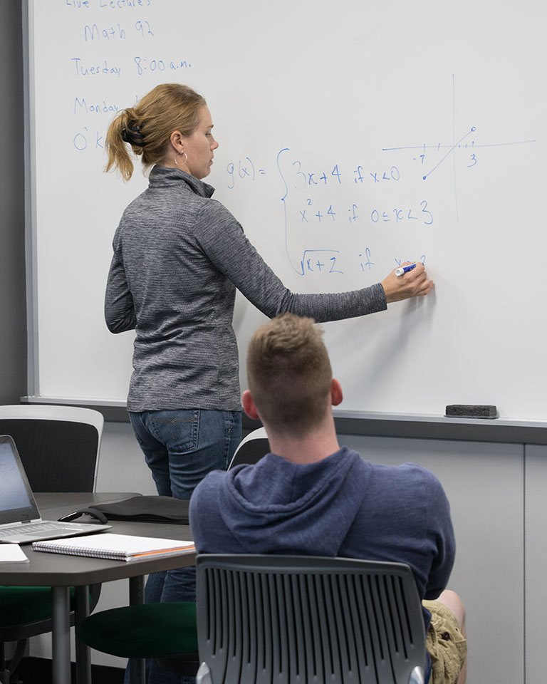 mathematics instructor at whiteboard
