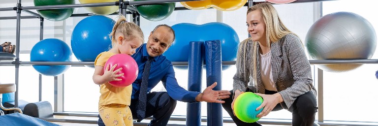 PT student and instructor working with child