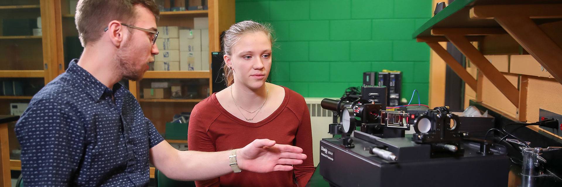 physics student examining laser research station