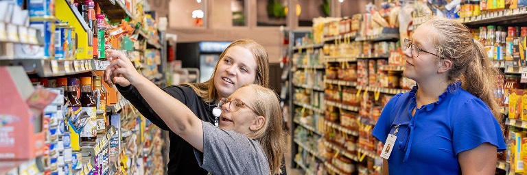 students helping OT patient in grocery store