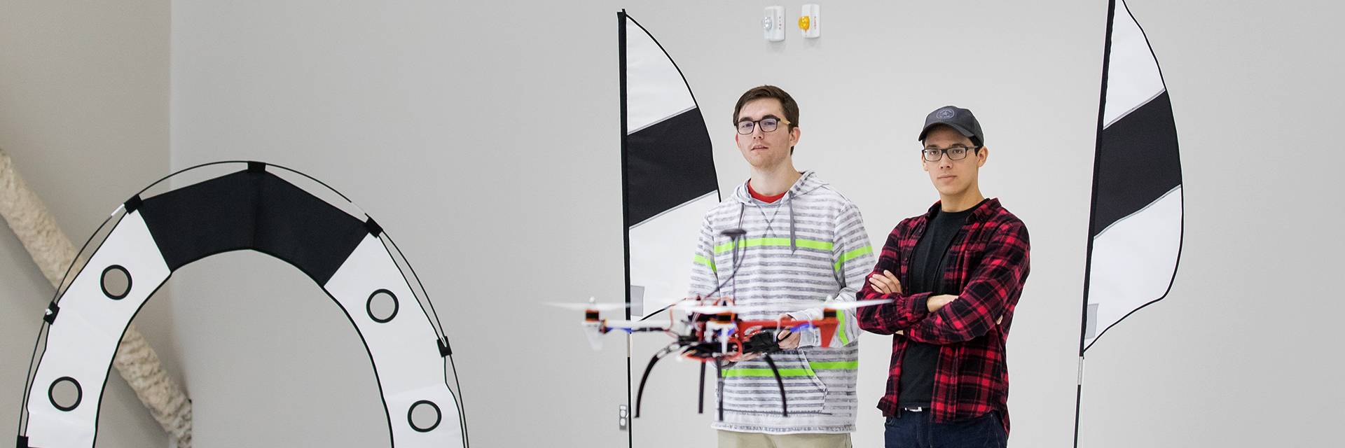 two unmanned aircraft system operations students controlling drone in race