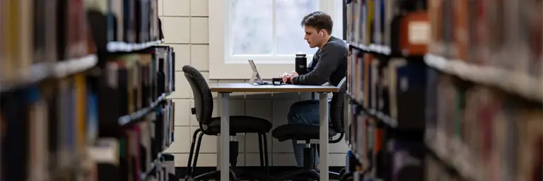 UND Student Writing in Library