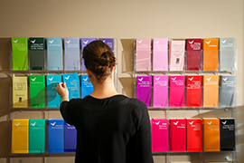 Person looks at pamphlets sorted on a wall.