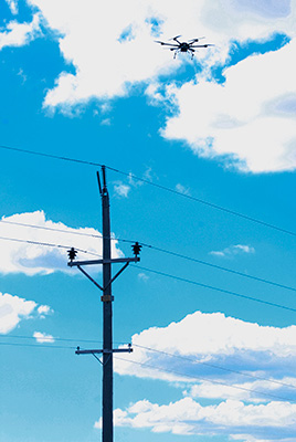 drone flys over power lines