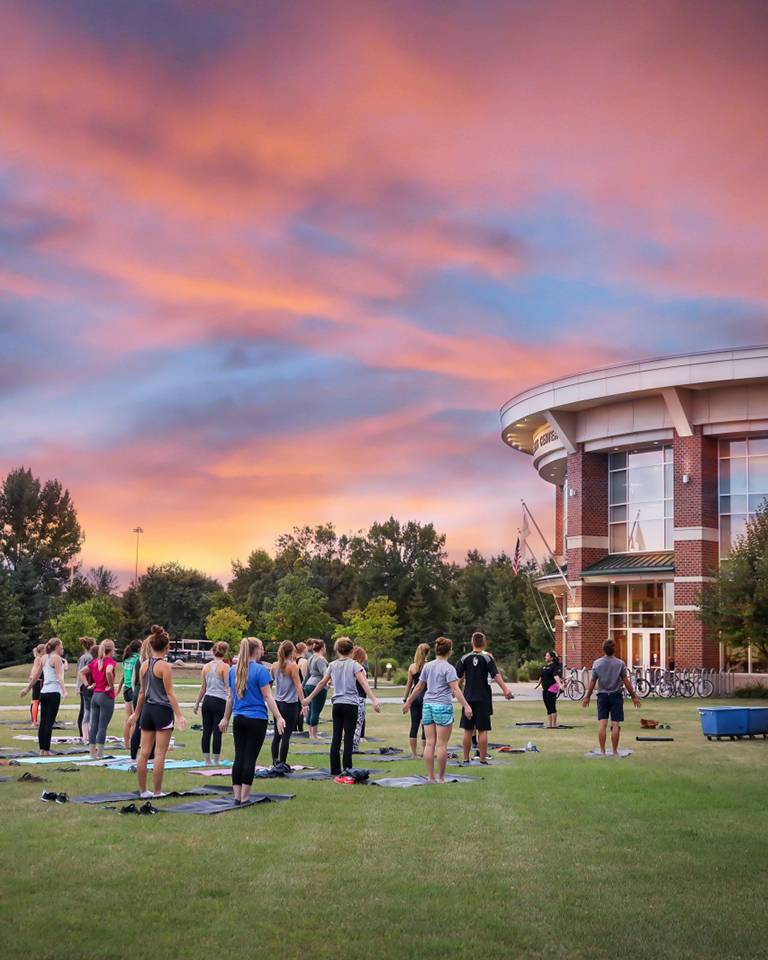 students doing yoga outside of the wellness center