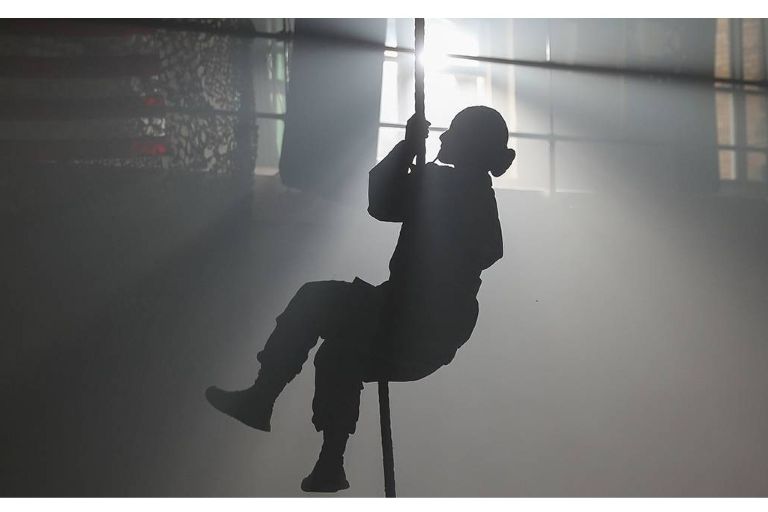 ROTC cadet climbs a rope