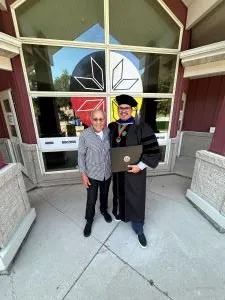 Student taking a selfie with President Armacost at commencement