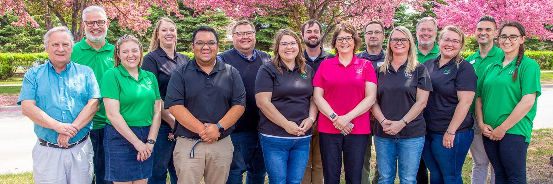 the housing and residence life staff in front of spring trees