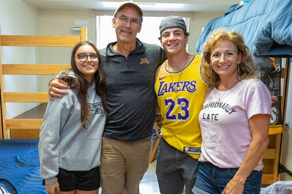 a family standing in a residence hall room